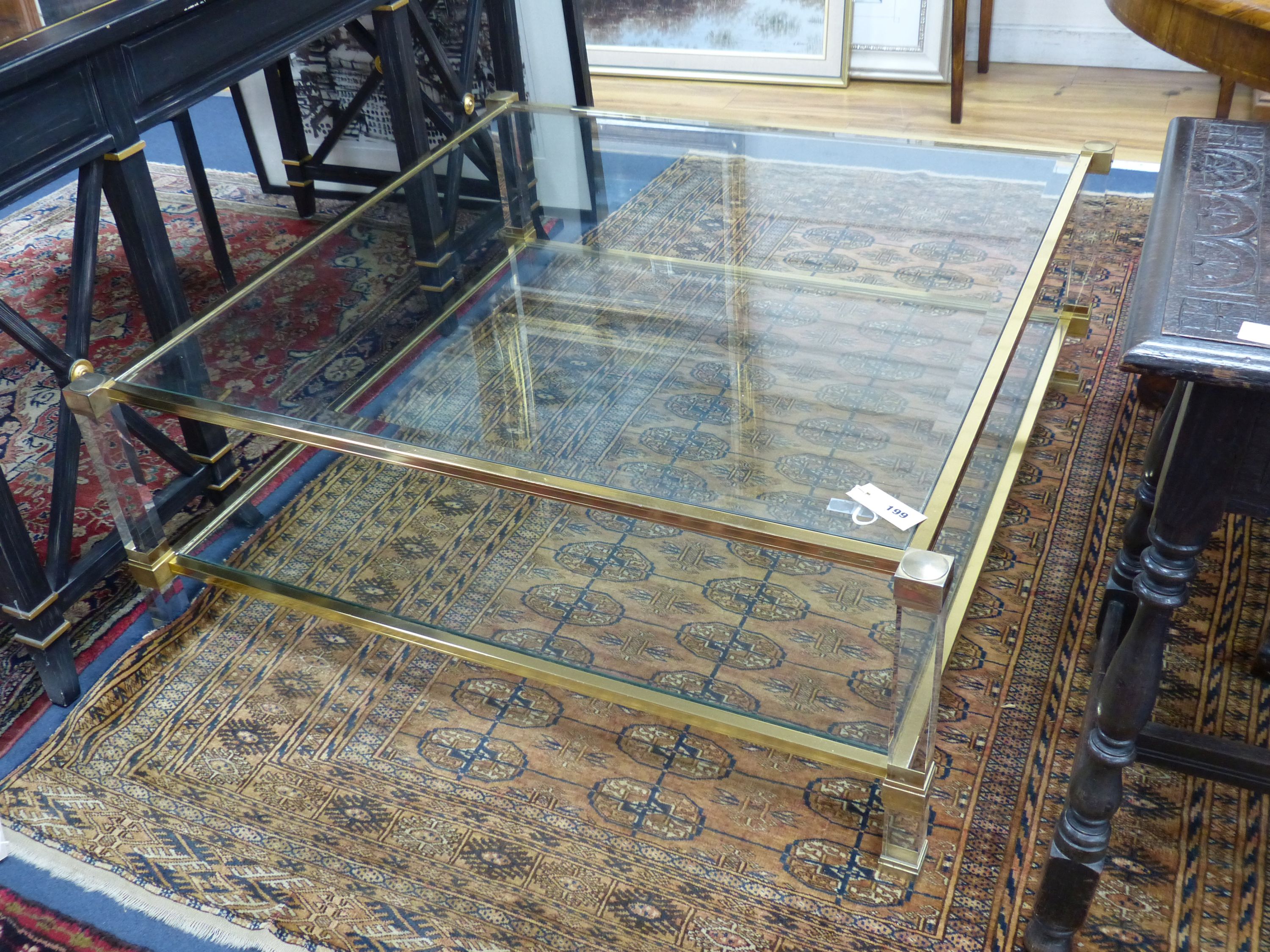 A contemporary square two tier brass framed glass coffee table, width 103cm, height 39cm